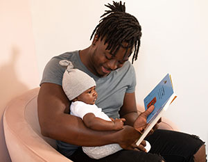 man reading to baby