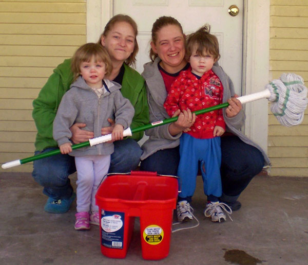 Smiling women and preschoolers with mop and bucket