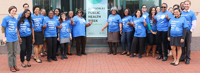 APHA staff members standing in front of NPHW sign