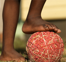 Bare foot on rubber band ball