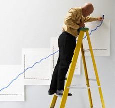 Man on ladder drawing graphs