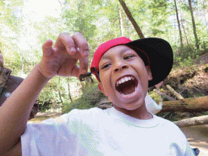 Shayne, a fourth-grade student at Chenoweth Elementary School in Louisville, Kentucky, examines a crayfish as part of Kentucky’s West Louisville Outdoor Recreation Initiative