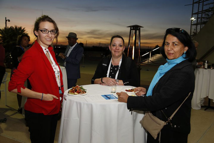 three smiling women with sunset in background
