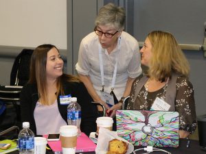 woman talks with two people at table