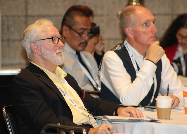 men listening to speaker