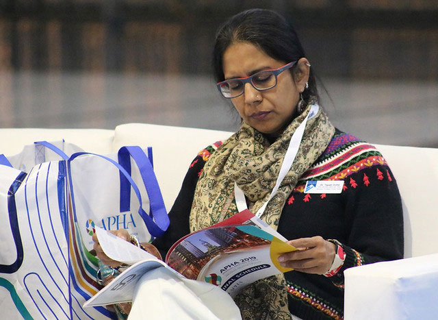 woman looking at Annual Meeting program