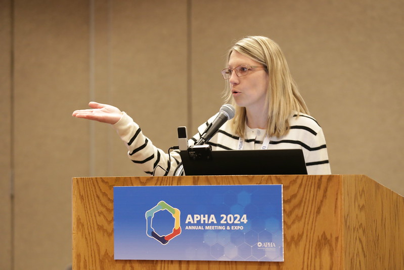 Woman speaking at a podium at APHA annual meeting