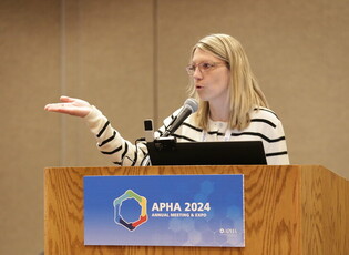 Woman speaking at a podium at APHA annual meeting