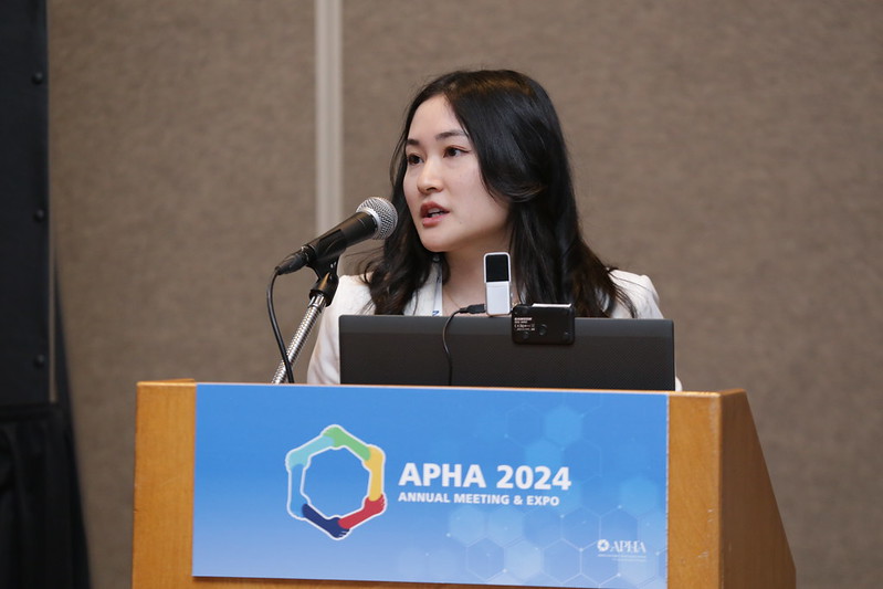 Woman speaking at podium at APHA 2024