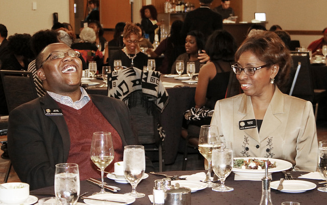 man laughing as woman looks on
