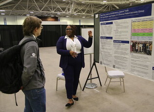 Man with backpack and woman giving poster presentation at APHA annual meeting
