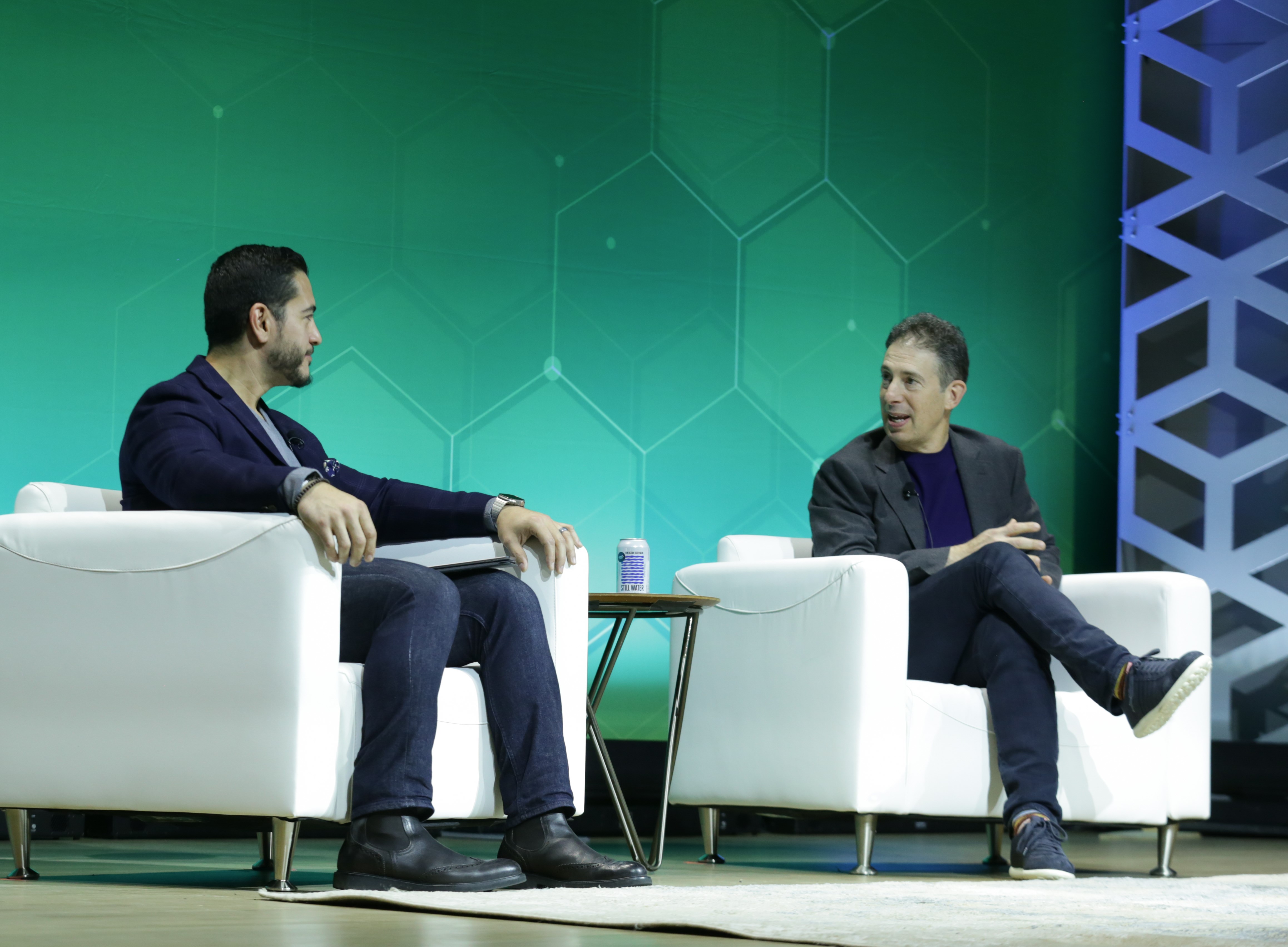 Photo of two presenters in white armchairs