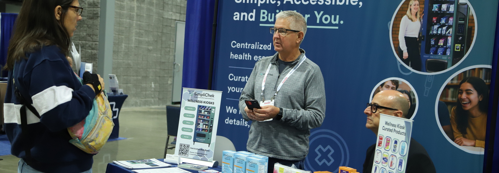 Photo of an exhibitor at the 2025 Annual Meeting. Three people are standing at a table. 