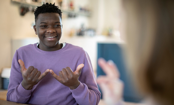 Smiling Teenage Boy Using Sign Language