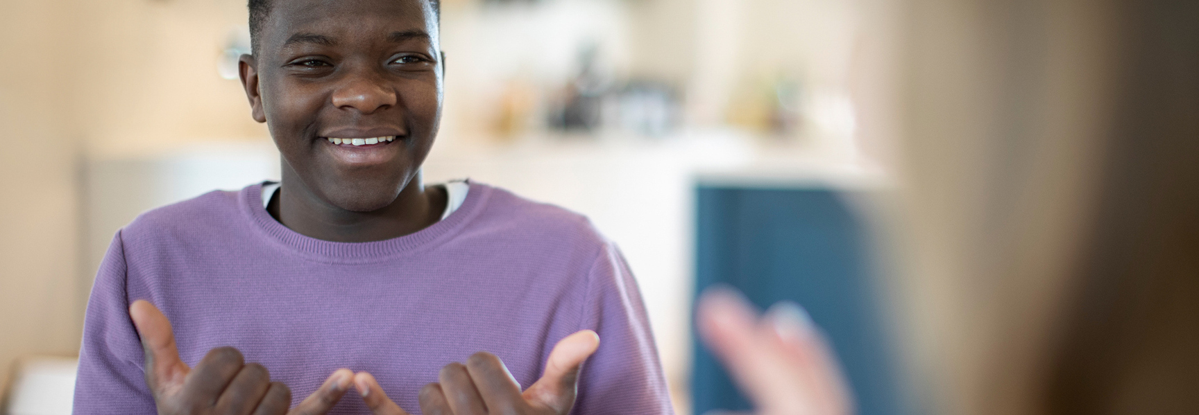 Smiling Teenage Boy Using Sign Language