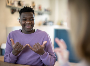 Smiling Teenage Boy Using Sign Language
