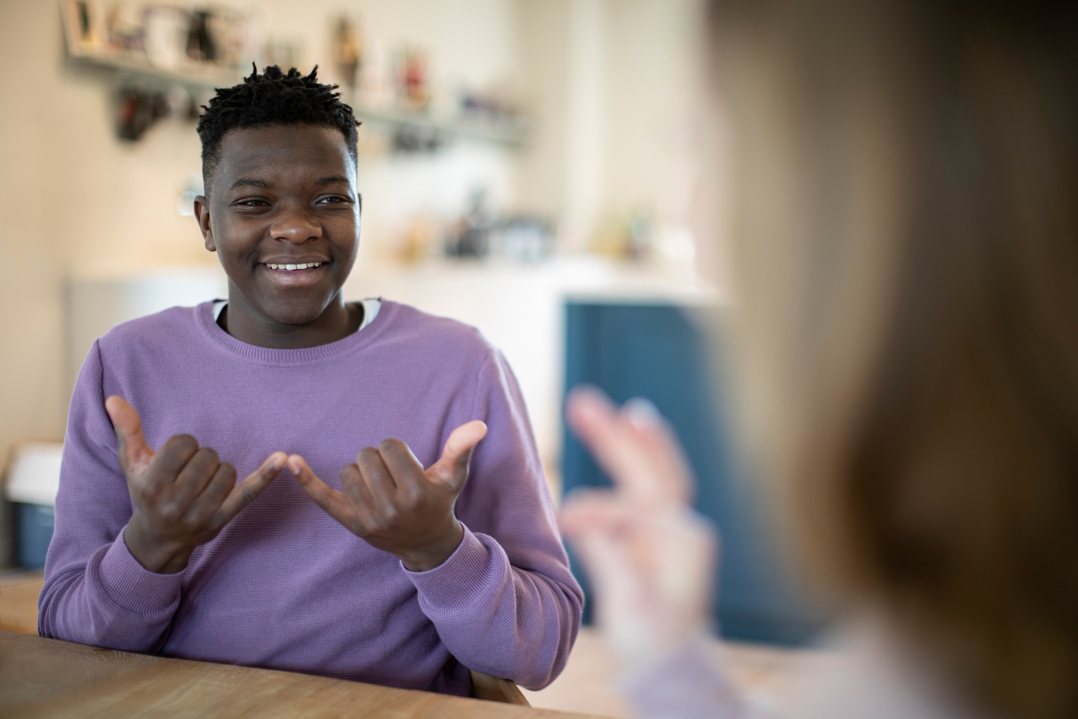 Smiling Teenage Boy Using Sign Language