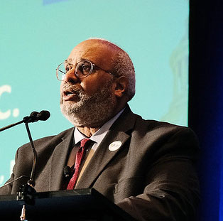 Georges Benjamin speaking into microphone