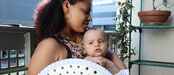 An infant sits on a woman's lap