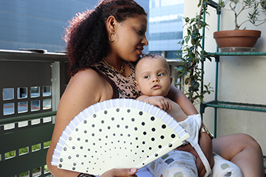An infant sits on a woman's lap