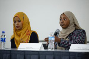 two women in headscarfs at microphone