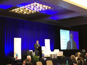 Georges Benjamin on stage addressing crowd