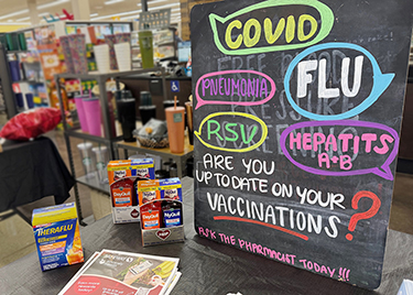 A sign displays vaccination options at a Safeway in Arlington, Virginia