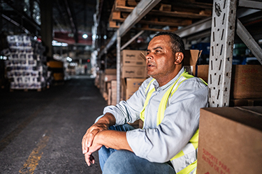 Warehouse worker takes a break on a hot day in the building