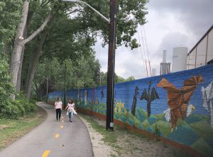 two people walking on paved trail