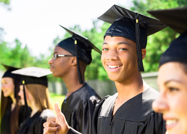 smiling boy in cap and gown