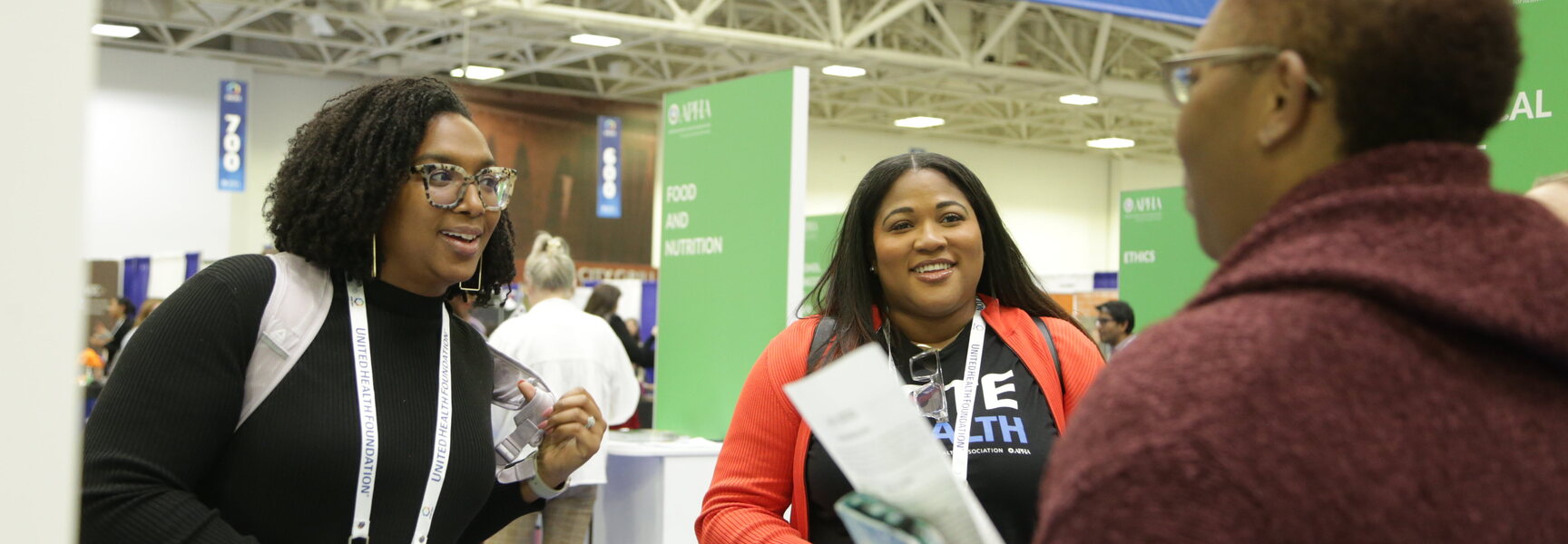 Members at the APHA 2024 meeting talking at a booth