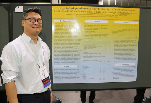 smiling man in front of Annual Meeting research poster