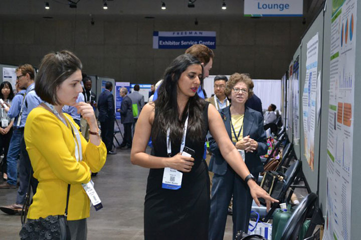 women looking at Annual Meeting poster