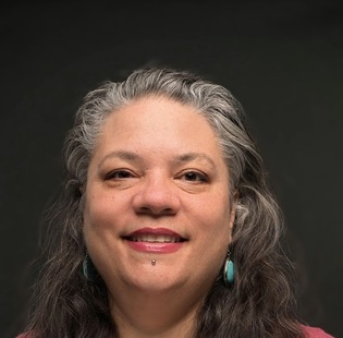 A smiling woman with long hair and a red shirt 