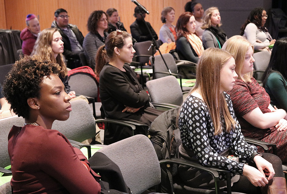 People sitting in chairs at a conference 