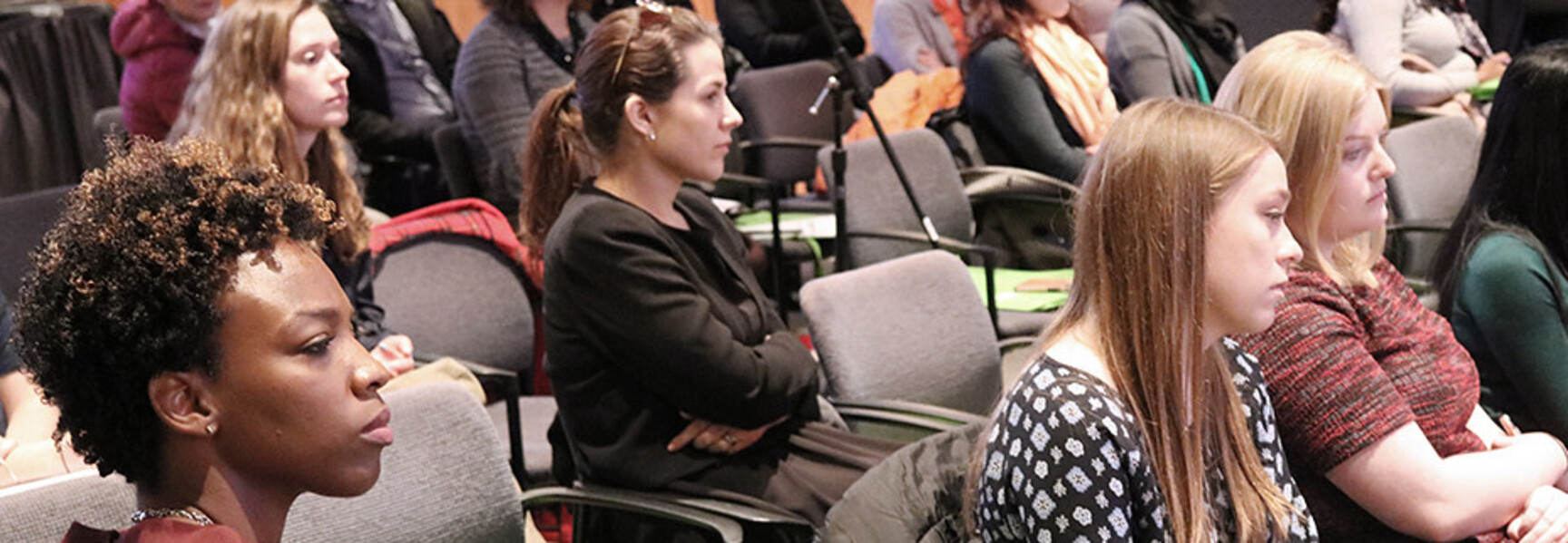 People sitting in chairs at a conference 