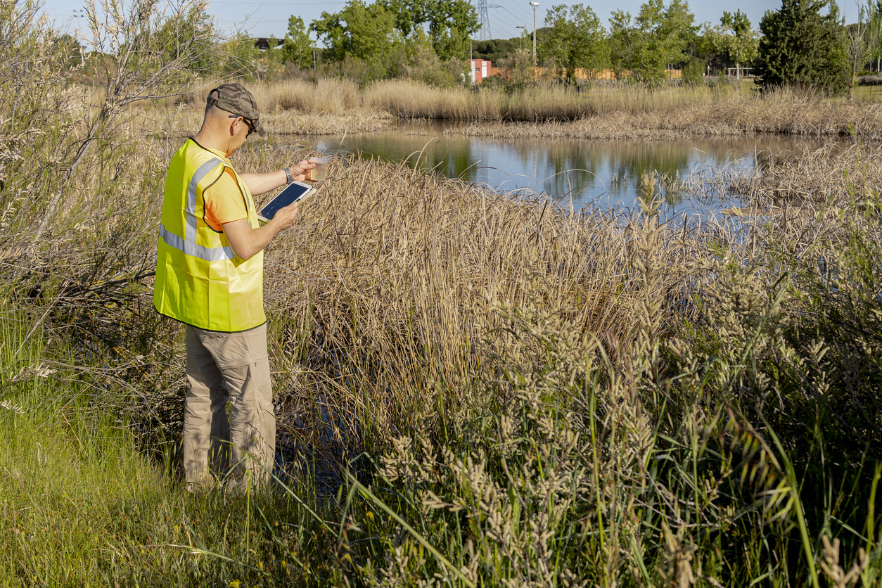 Environmental technician in a small pond in a rural environment.