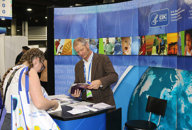 man and woman peruse publications at Expo booth