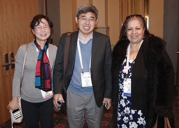 two smiling women and one man with Annual Meeting badges
