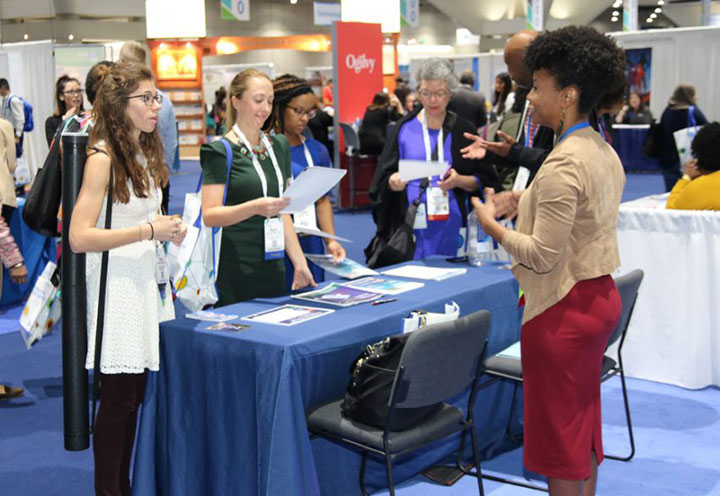 people gathered at Public Health Expo booth talking