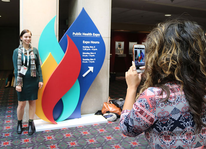women taking photo next go giant Annual Meeting logo