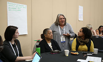 women speaking at table