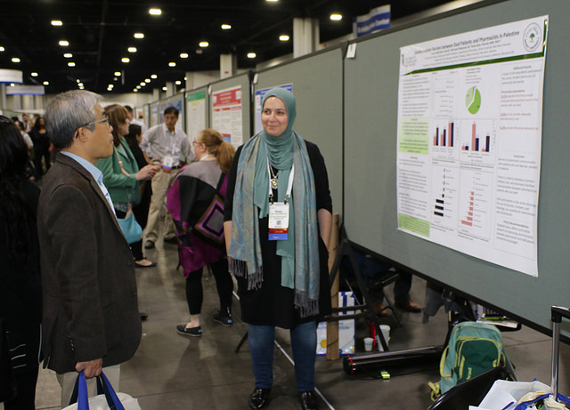 woman standing in front of poster