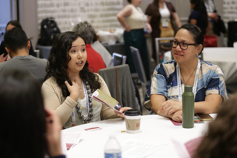 Two women at a table at APHA annual meeting
