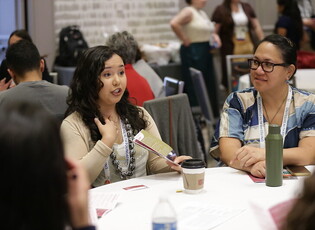 Two women at a table at APHA annual meeting