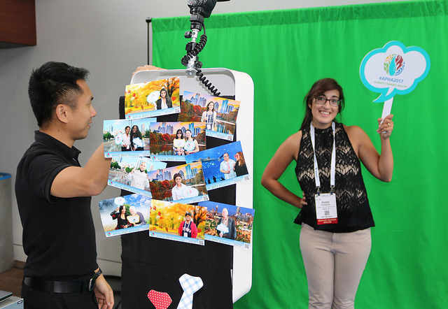 Man takes photo of woman in front of green screen