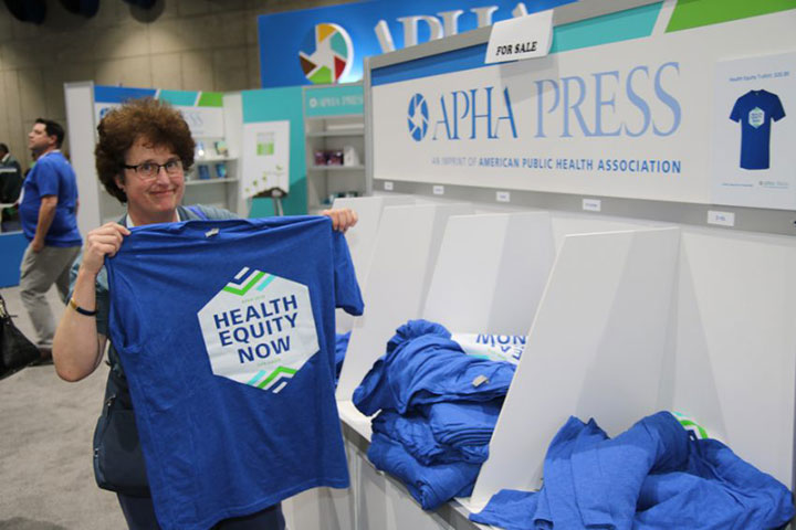 Woman holding Health Equity Now T-shirt
