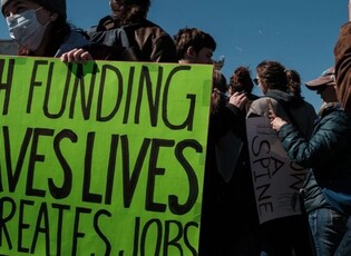 NIH staff protesting with a green sign
