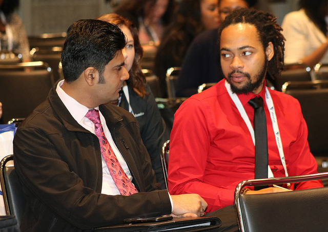 two seated men talking
