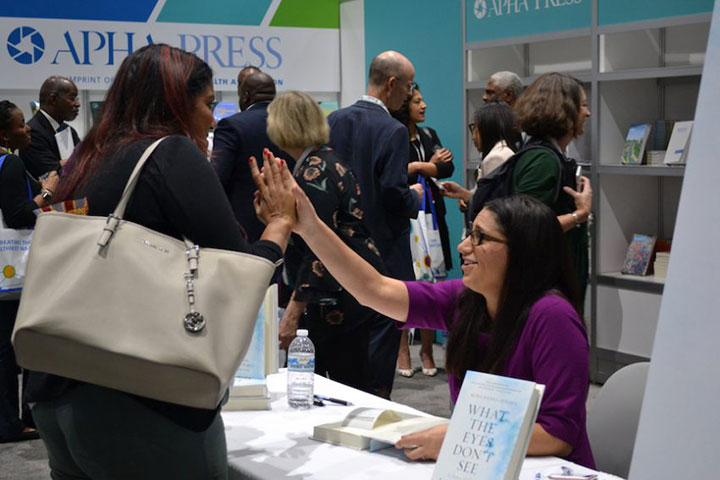 women high fiving at book signing table